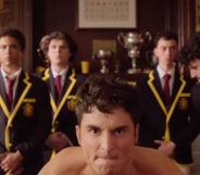 A still from Overcompensating featuring Benito Skinner on all fours in skimpy underwear preparing to be hit on the backside by a cricket bat held by Adam DiMarco.