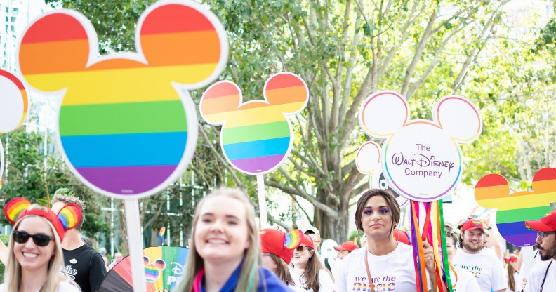 Orlando, Florida. October 15, 2022. Woman with a sign and Group of members of the LGBTIQIA+ And Allied Employees of The Walt Disney Company in the Come Out With Pride Orlando parade on the E Central Blvd street.