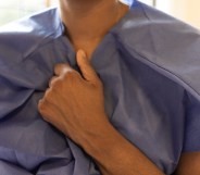 Person clutching a medical gown.