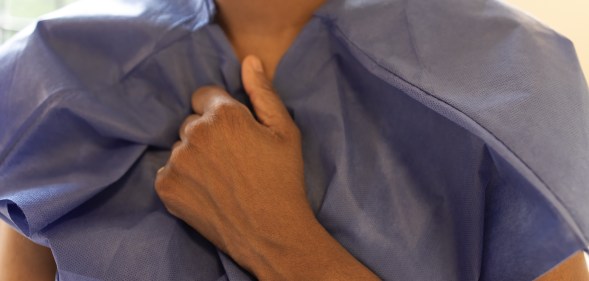 Person clutching a medical gown.
