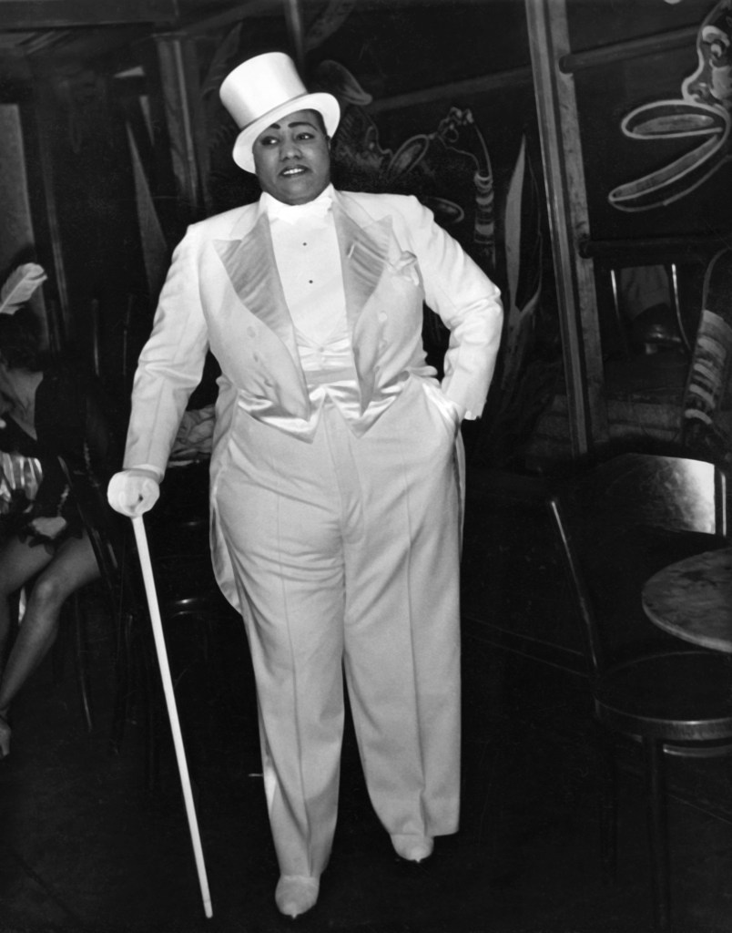 Black and white image of Gladys Bentley in a top hat, suit and cane