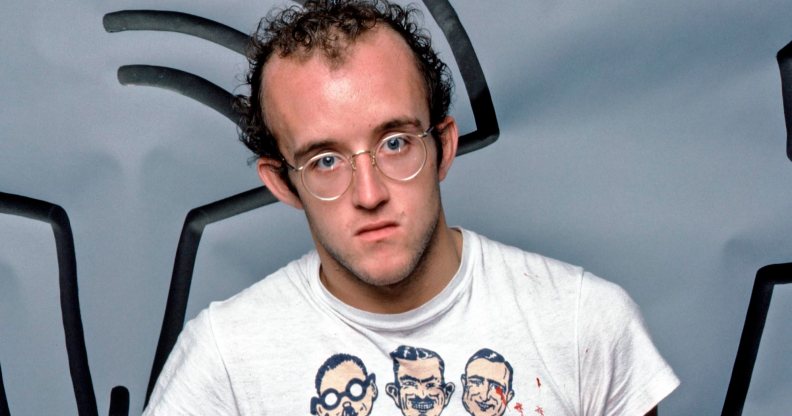 Graffiti and visual artist Keith Haring photographed with one of his paintings in April 1984. Photo by Jack Mitchell/Getty Images.