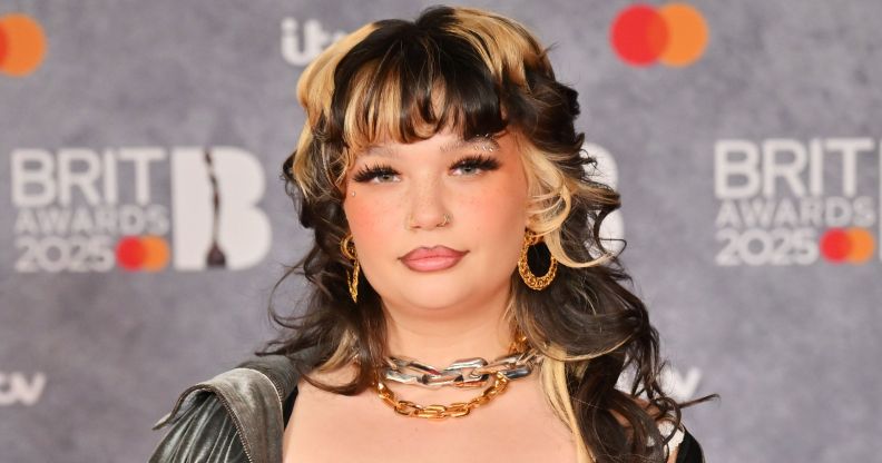 Lola Young poses for photos on the BRIT Awards red carpet