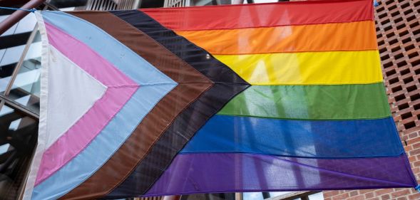 A Pride flag hung on a street.