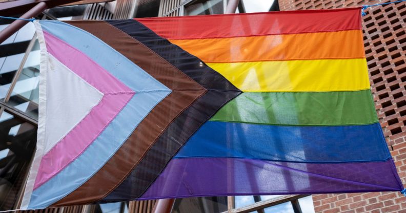 A Pride flag hung on a street.