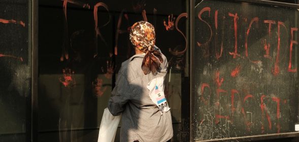 An activist leaving handprints on the windows of the NHS HQ in Waterloo Road, London.