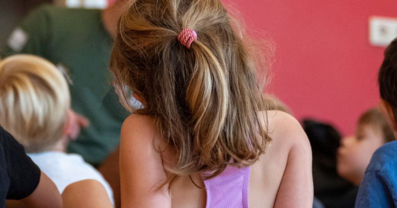 The back of a toddler in a class.