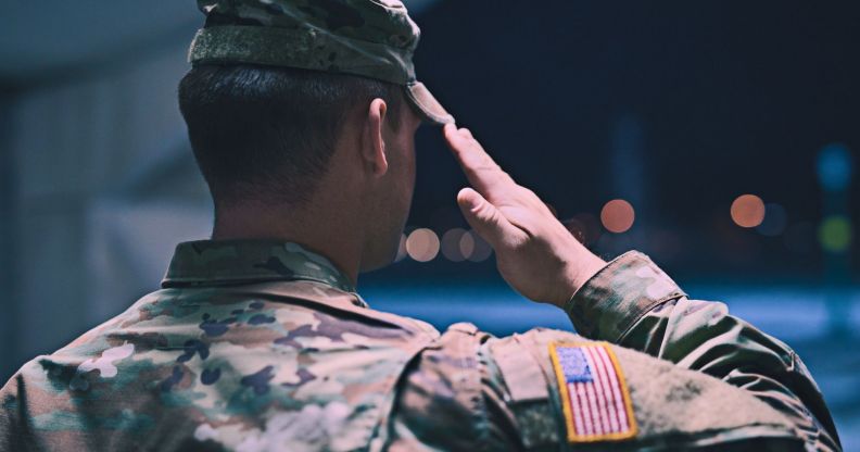 The back profile of a soldier saluting.
