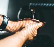 A person washing their hands in a bathroom.