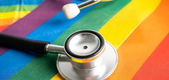 A stethoscope on top of an LGBTQ+ flag.