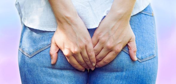 An edited picture of someone holding their rear-end.