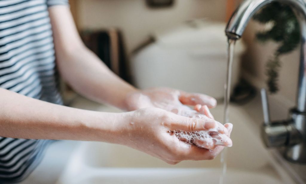 An unidentified person washing their hands.