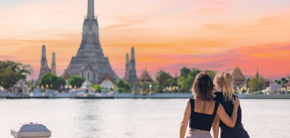 Two women discover Bangkok riding a boat in Chao Phraya river looking out from the boat