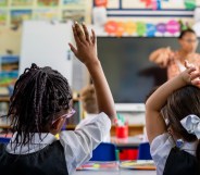 Primary school students sitting in a classroom being taught by a teacher.