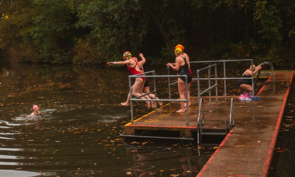 Swimmers leaping into Hampstead Heath Ladies Pond.