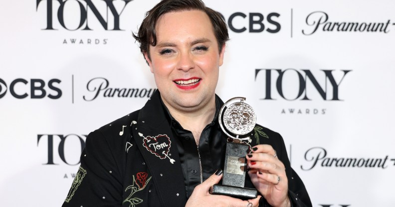 Jak Malone with his Tony Award. Wearing an embazzled black blazer