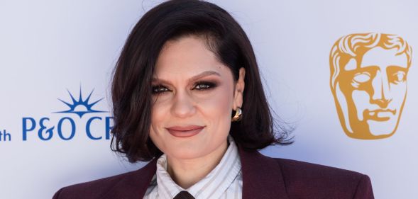 Jessie J on the BAFTA red carpet in 2025 wearing a pin-striped shirt, tie and burgundy blazer.