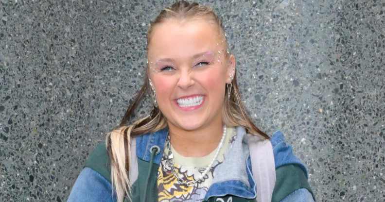 JoJo Siwa in a multi-coloured jacket smiling.