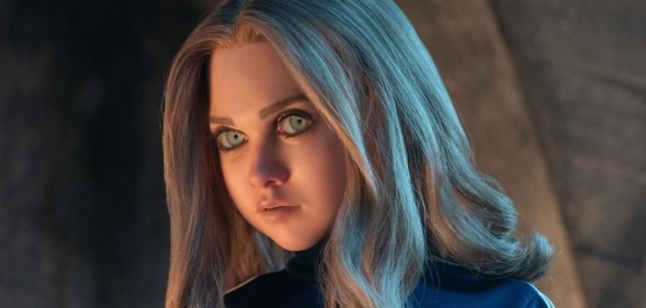 AI robot M3GAN. She's looking into camera, long blonde hair falling over her blue shirt.