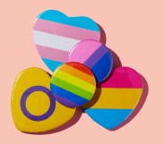 some different LGBTIQA badges, patterned with flags such as the lesbian flag, the transgender pride flag or the bisexual pride flag, on a pink background