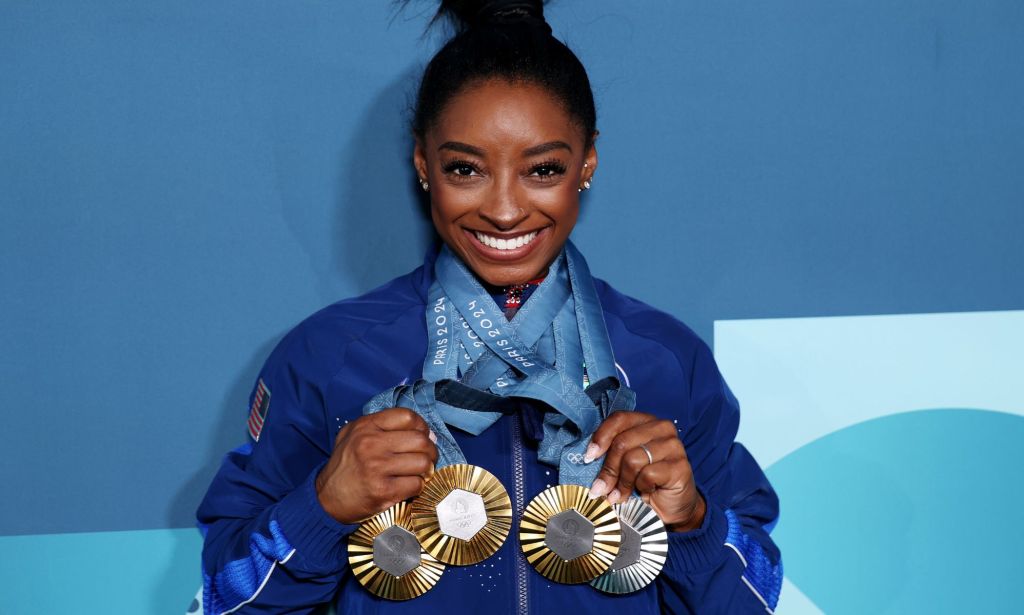 Simone Biles, pictured with three gold medals and a silver medal.