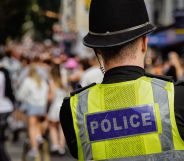 The back of a police officer looking at a crowd.