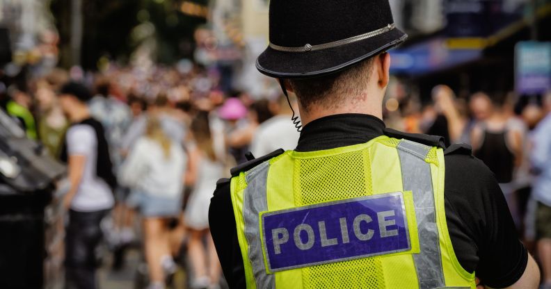 The back of a police officer looking at a crowd.