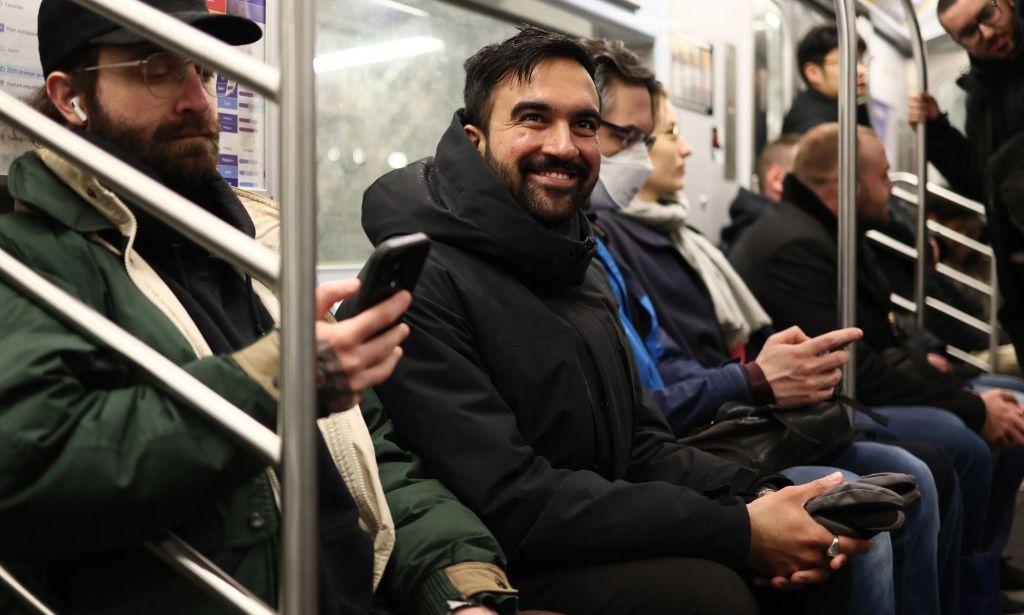 Zahron Mamdani pictured smiling as he takes the New York subway.