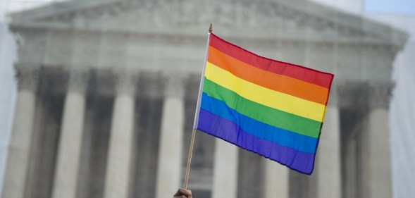 A same-sex marriage supporter waves a rainbow flag in front of the US Supreme Court