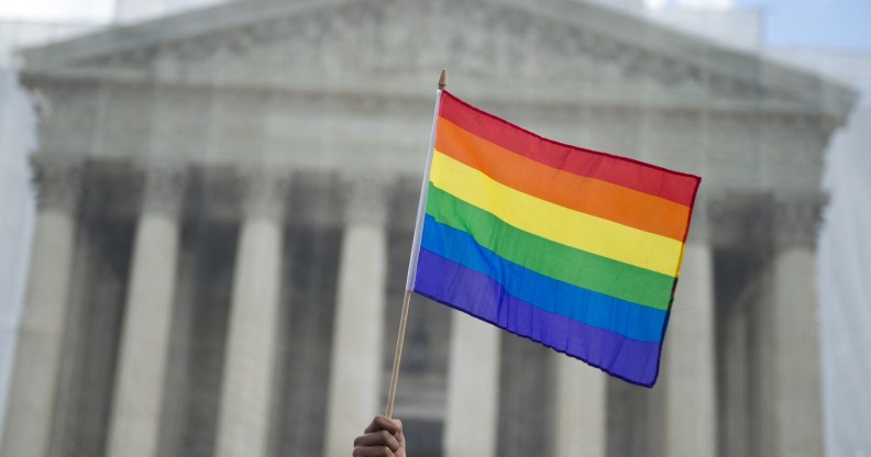 A same-sex marriage supporter waves a rainbow flag in front of the US Supreme Court