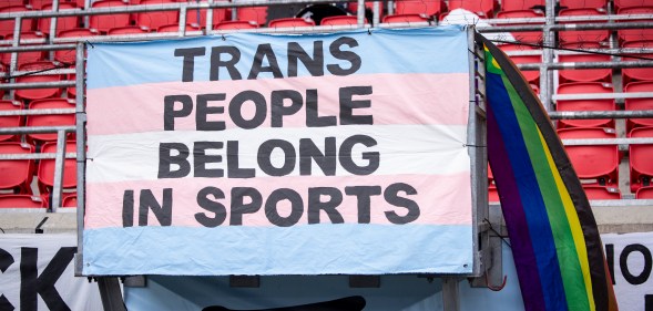 "Trans people belong in sports" banner.
