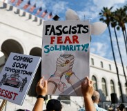 LOS ANGELES, CALIFORNIA - JULY 17: A demonstrator holds a sign reading 'Fascists Fear Solidarity!' at a 'Good Trouble Lives On' rally outside City Hall on July 17, 2025 in Los Angeles, California.