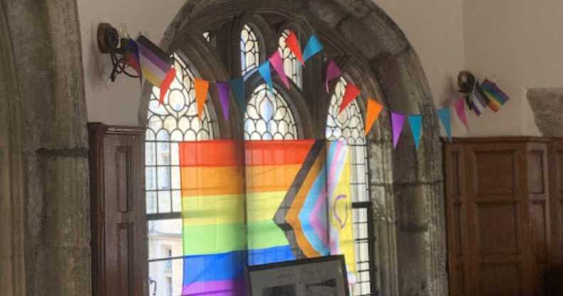 Pride flag across the window of an Oxford college.
