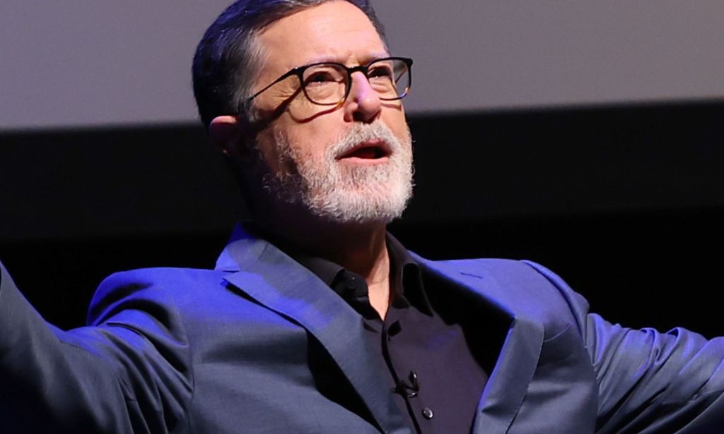 A picture of Stephen Colbert with his arms outstretched.