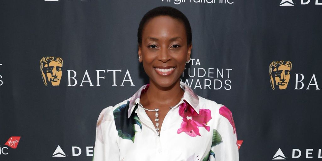 The Pitt star Tracy Ifeachor smiles at a BAFTA red carpet event, wearing a pink, white and green floral shirt.