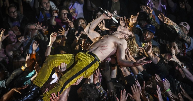 Interview with the Vampire still: Sam Reid as rock star Lestat crowd surfing shirtless in velvet trousers.