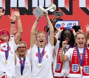Leah Williamson of England lifts the UEFA Women's EURO trophy on stage during the England Women's team victory parade