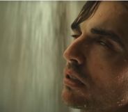 Dave Franco as Tim in horror movie Together. He is in the shower with wet slicked back brown hair, his eyes rolling back in his head.