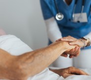 Close-up of caregiver holding senior client hand.