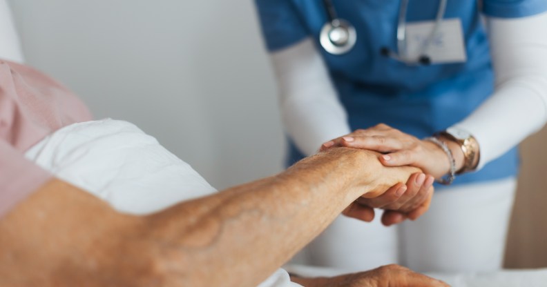 Close-up of caregiver holding senior client hand.