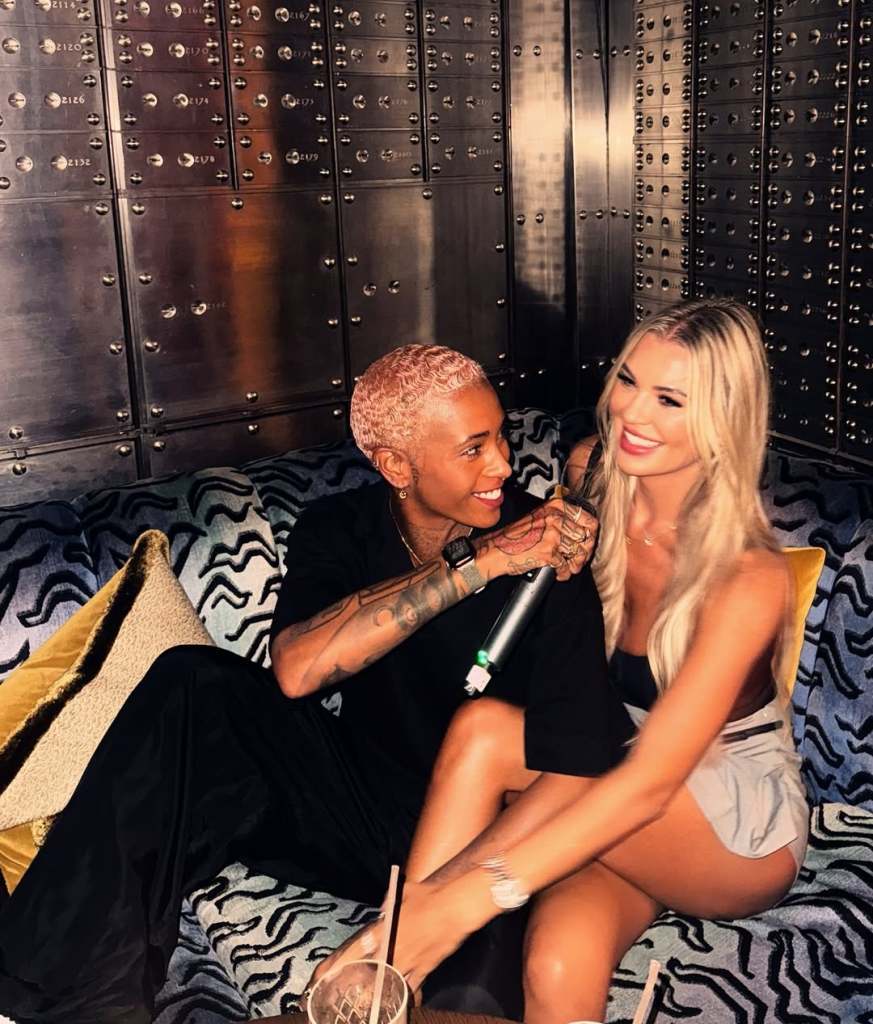 DJ Roxxxan and Christine McGuinness sitting on a couch together.