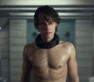 A shirtless Hunter Doohan in Wednesday season two in a dingy dungeon.