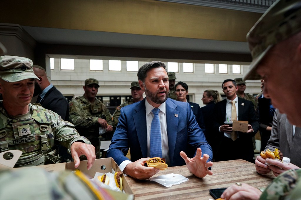 US vice president JD Vance eats a Shake Shack hamburger with members of the National Guard during a visit to Union Station on 20 August 20, 2025.