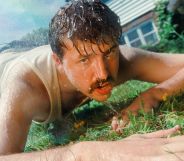 Kai Bosch lays on the grass wearing a white vest and blue jean shorts. He is dripping wet.