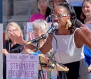 Activist Kimiya Factory speaks next to a sign that reads "stronger together"