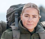 Lucy Spraggan poses and looks stern while wearing military gear and a back pack.