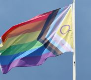 A Progress Pride flag on a flagpole.