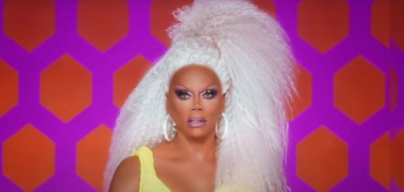 RuPaul on the Drag race judging panel in a yellow crop top.