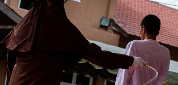 A man is seen receiving caning for violating sharia law in Lhokseumawe, on March 21, 2023, in Aceh Province.