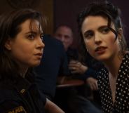 Aubrey Plaza and Margaret Qualley in Honey, Don’t. Plaza is in a police uniform and Qualley is in a polka dot black and white dress.
